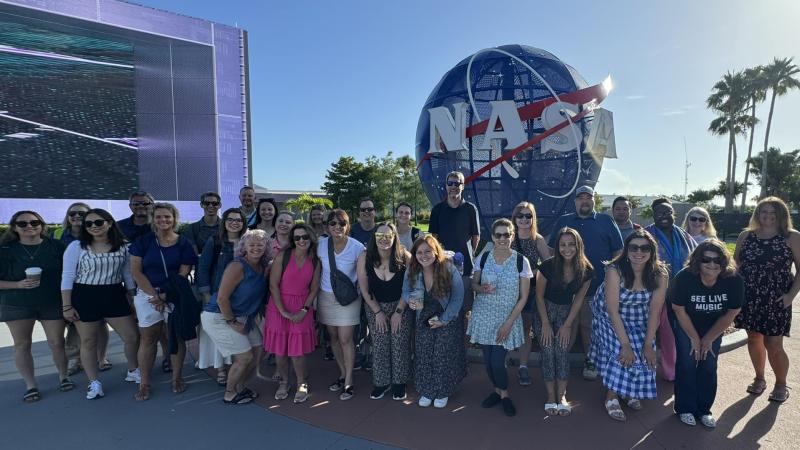 photo of group of educators in front of NASA sign