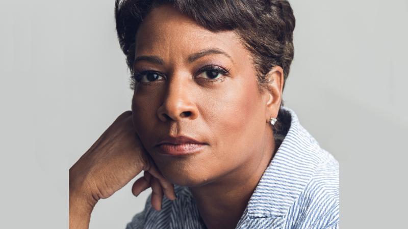 a headshot of Dawn Porter wearing a blue-and-white seersucker jacket.