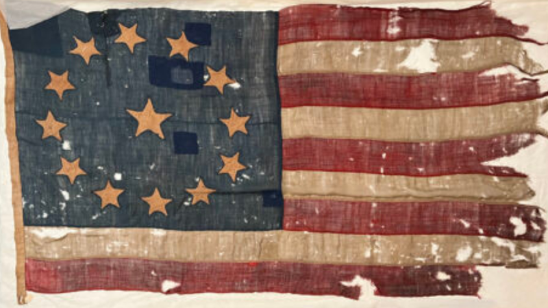 Colonial era American flag with 13 stars, 9 stripes and holes in the flag